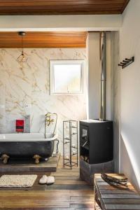ein Bad mit einer Badewanne und einem Kamin in der Unterkunft Schatz Chalé Witmarsum in Palmeira
