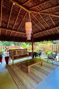 a patio with two benches and a thatched roof at Pousada Pipa Soul in Pipa