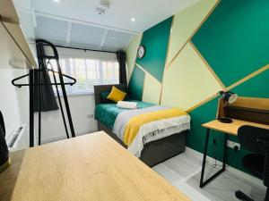 een kleine kamer met een bed en een bureau bij Stylish studio in Milton Keynes