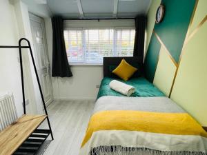 een kleine slaapkamer met een bed in een kamer bij Stylish studio in Milton Keynes