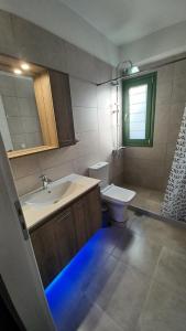 a bathroom with a sink and a toilet with a blue light at MILIASIA in Kondáraina +48 photos