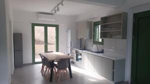 a kitchen with a wooden table and some chairs at MILIASIA in Kondáraina