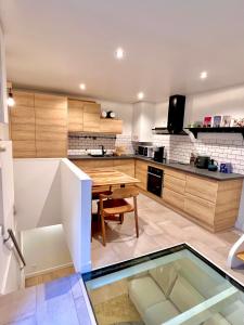 a kitchen with a table and a glass floor at Maison d'architecte Triplex in Paris