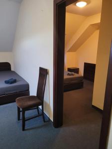 Habitación con cama, silla y espejo. en Gangnam Hotel en Ciągowice