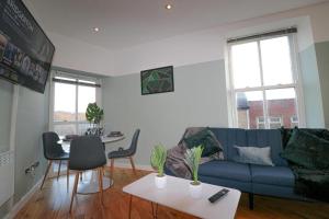 uma sala de estar com um sofá azul e uma mesa em Simple 2 Bed in Central Dewsbury - Sleep 4 em Dewsbury