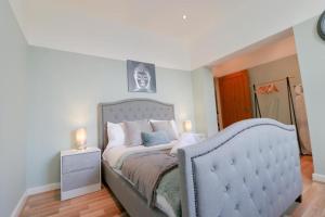 a bedroom with a bed with a blue bed frame at Simple 2 Bed in Central Dewsbury - Sleep 4 in Dewsbury