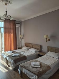 2 łóżka w pokoju hotelowym z ręcznikami w obiekcie FRESH Hotel Kobuleti w Kobuleti