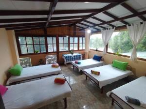 a room with four beds in a room with windows at wellassa homestay in Badulla
