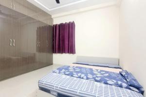 a bedroom with a bed and a purple curtain at Verizon stays 2BHK near Nizampet in Hyderabad