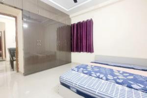 a bedroom with a bed and a purple curtain at Verizon stays 2BHK near Nizampet in Hyderabad