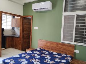 um quarto com uma cama com um edredão azul e uma janela em Smart living Opal em Indore
