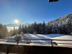 una montaña cubierta de nieve con el sol en el fondo en Buena Vista Mountain Lodge, en Mittersill