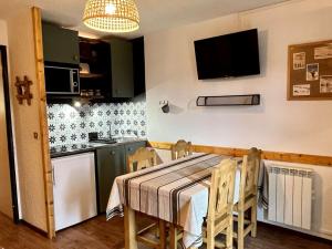 a dining room with a table and a kitchen at Appartement Huez, 2 pièces, 5 personnes - FR-1-405-346 in LʼHuez