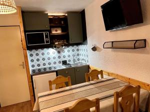 a small kitchen with a table and chairs in a room at Appartement Huez, 2 pièces, 5 personnes - FR-1-405-346 in LʼHuez