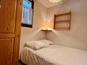 ein kleines Schlafzimmer mit einem Bett mit Lampe in der Unterkunft Appartement Huez, 2 pièces, 5 personnes - FR-1-405-346 in Huez
