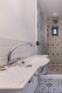 baño blanco con lavabo y ventana en Maison Perle de Marshan en Tánger