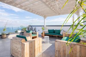 d'une terrasse avec un canapé vert et un mobilier en bois. dans l'établissement Maison Perle de Marshan, à Tanger