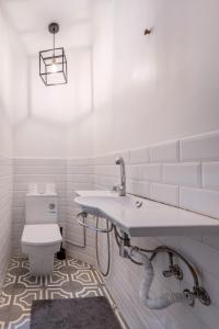 La salle de bains blanche est pourvue d'un lavabo et de toilettes. dans l'établissement Maison Perle de Marshan, à Tanger