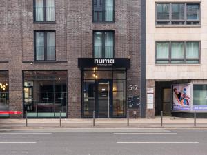 a brick building with a running store on a street at Numa Frankfurt Bloc in Frankfurt