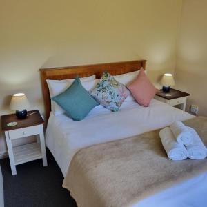 a bedroom with two beds with pillows and two tables at Little Louisa in Port Elizabeth