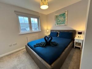 Un dormitorio con una cama azul con una cinta. en Faillie en Inverness