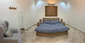 a bedroom with a bed with blue pillows on it at منتجع مطل الريم in Taif