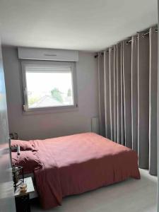 a bedroom with a pink bed and a window at Appartement Cosy Goussainville - Aéroport CDG, Parc des expositions Villepinte, Astérix, JO 2024 in Goussainville