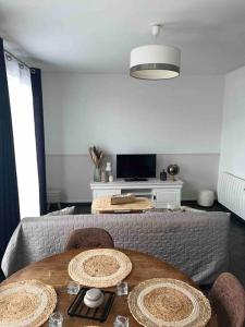 a living room with a table and a tv at Appartement Cosy Goussainville - Aéroport CDG, Parc des expositions Villepinte, Astérix, Mer des sables, Aéroville, O Parinor in Goussainville