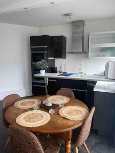 a kitchen with a wooden table and chairs in it at Appartement Cosy Goussainville - Aéroport CDG, Parc des expositions Villepinte, Astérix, Mer des sables, Aéroville, O Parinor in Goussainville +6 photos