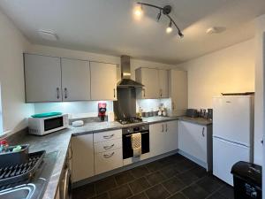 a kitchen with white cabinets and a stove top oven at Faillie in Inverness