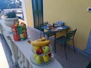 un plato de fruta en una mesa en un balcón en B&B VILLA PREZIOSA LAGO MAGGIORE en Lesa