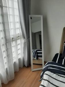 einen Spiegel in einem Zimmer mit einem Bett und einem Spiegel in der Unterkunft MSA Homestay in Kota Bharu