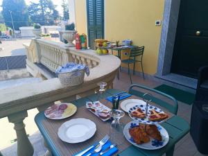 une table avec des assiettes de nourriture sur un balcon dans l'établissement B&B VILLA PREZIOSA LAGO MAGGIORE, à Lesa