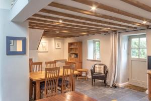 a kitchen and dining room with a wooden table and chairs at Rosewall in St Ives