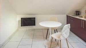 cocina con mesa y sillas y TV en Smart Confort 5 - Appartement confort et stylé, en Troyes