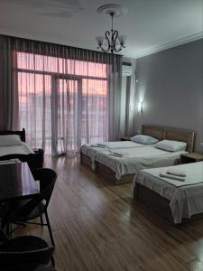 a bedroom with two beds and a table and chairs at FRESH Hotel Kobuleti in K'obulet'i