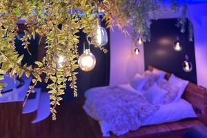 een paarse kamer met een bank en verlichting bij Love Room Cholet Le Double L in Cholet
