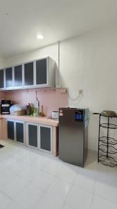 y cocina con encimera y nevera. en Yamad Homestay Langkawi, en Kuah