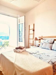 ein Schlafzimmer mit einem großen Bett und einem großen Fenster in der Unterkunft Villa avec vue T2 à T5 Duo de la Baie in Le Robert