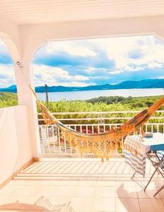 eine Hängematte auf einem Balkon mit Meerblick in der Unterkunft Villa avec vue T2 à T5 Duo de la Baie in Le Robert