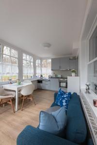 sala de estar con sofá azul y cocina en Haus Nordstrand FeWo Zingst, en Prerow