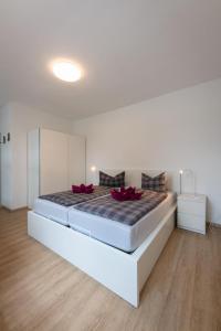 Un dormitorio con una cama grande con almohadas rojas. en Haus Nordstrand FeWo Zingst, en Prerow