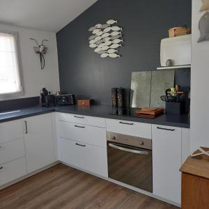 a kitchen with white cabinets and a counter top at La désirée à Noirmoutier in Noirmoutier-en-l'lle
