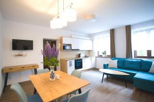 a living room with a blue couch and a table at Apartmány Lipno-Hory in Horní Planá