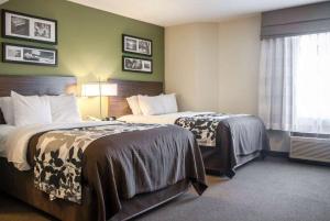 um quarto de hotel com duas camas e uma janela em Wingate by Wyndham Bel Air I-95 Exit 77A - APG Area em Edgewood