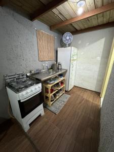 a kitchen with a stove and a sink and a refrigerator at Studio Morro das Pedras Floripa com Jacuzzi in Florianópolis
