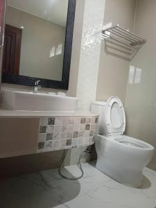 uma casa de banho com um WC, um lavatório e um espelho. em BangPo Resort em Ban Bang Po