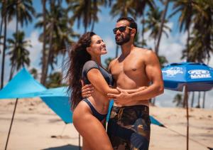 mężczyzna i kobieta stojący na plaży w obiekcie Reserva do Paiva suites w mieście Cabo de Santo Agostinho