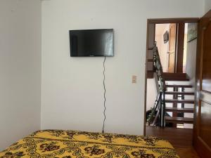 um quarto com uma cama e uma televisão na parede em Bhospedaje em Manizales