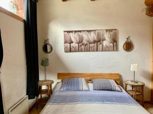 um quarto com uma cama com duas mesas e uma imagem na parede em Le Gite de Briey em Chalais
